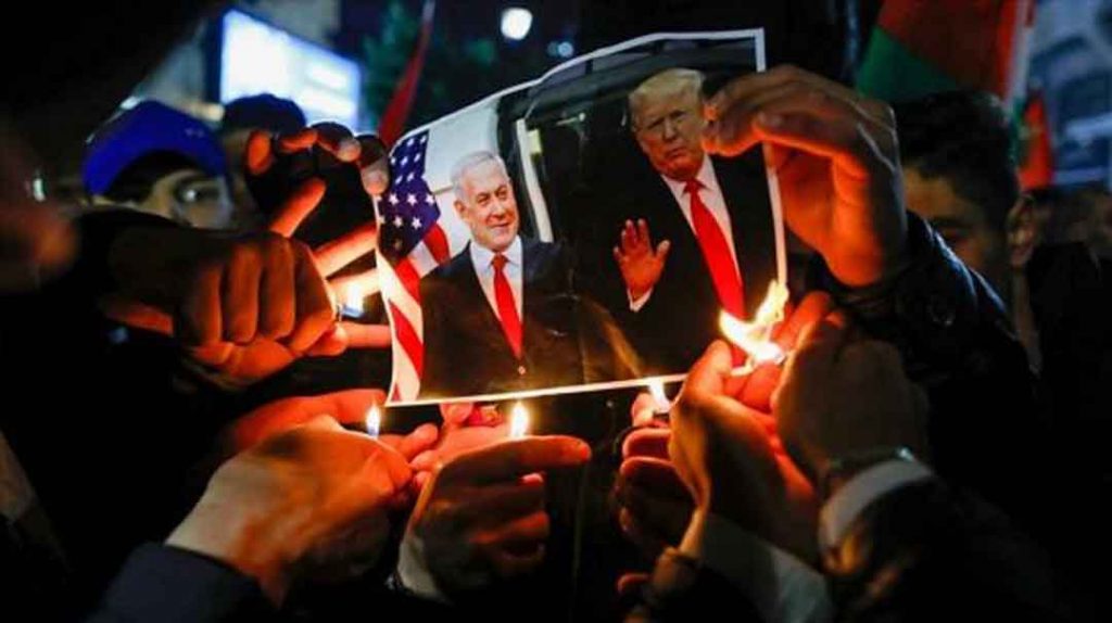Manifestantes palestinos queman una foto del presidente de EE.UU. y el premier israelí en Ramalá, 28 de enero de 2020. Foto: AFP.